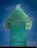 A large, green, translucent glass sculpture shaped like an upward-pointing arrow stands against a vivid blue sky. The layered texture of the glass creates a three-dimensional effect with subtle variations in color and transparency.
