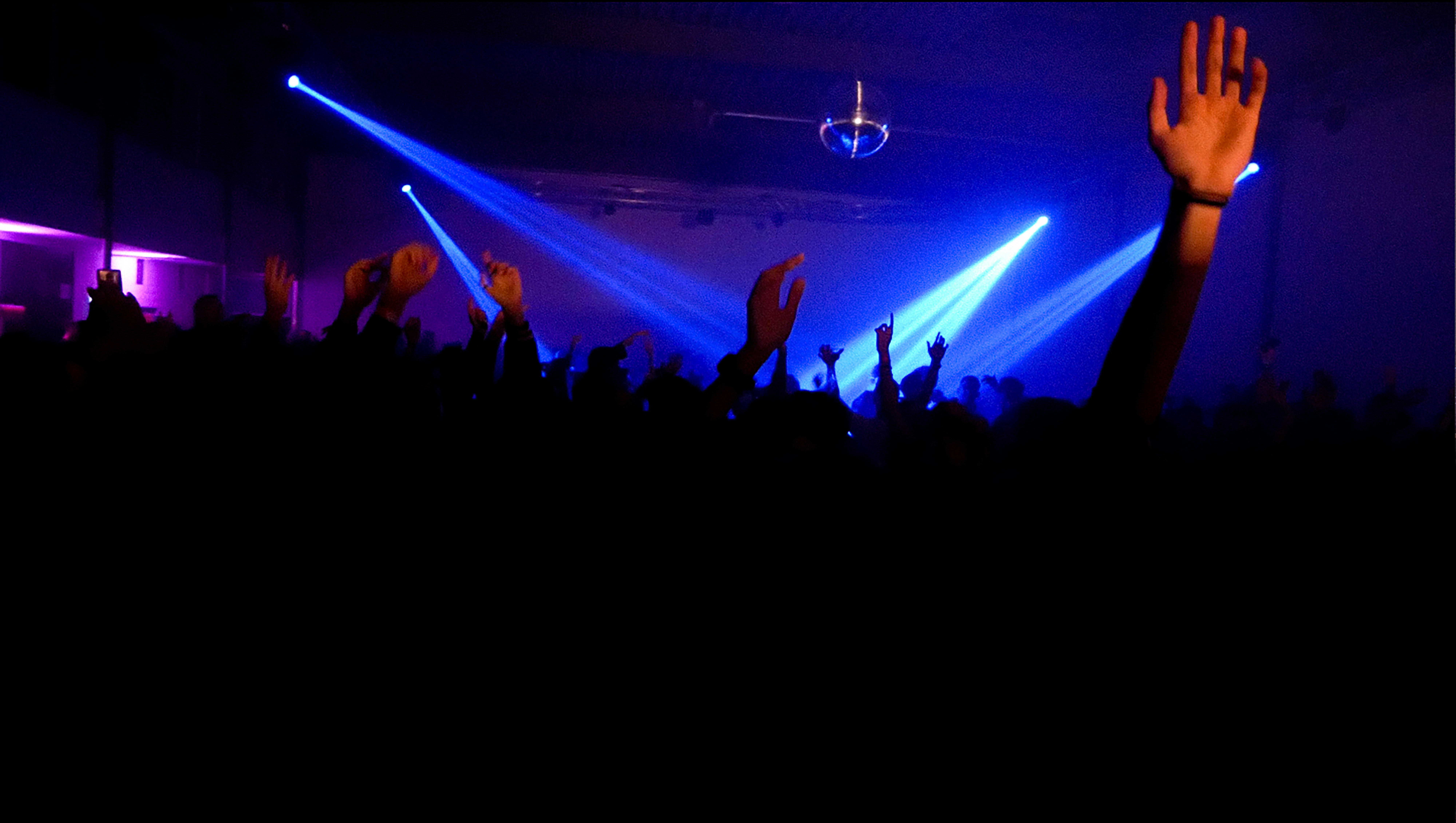 a crowd of people at a concert with their hands up