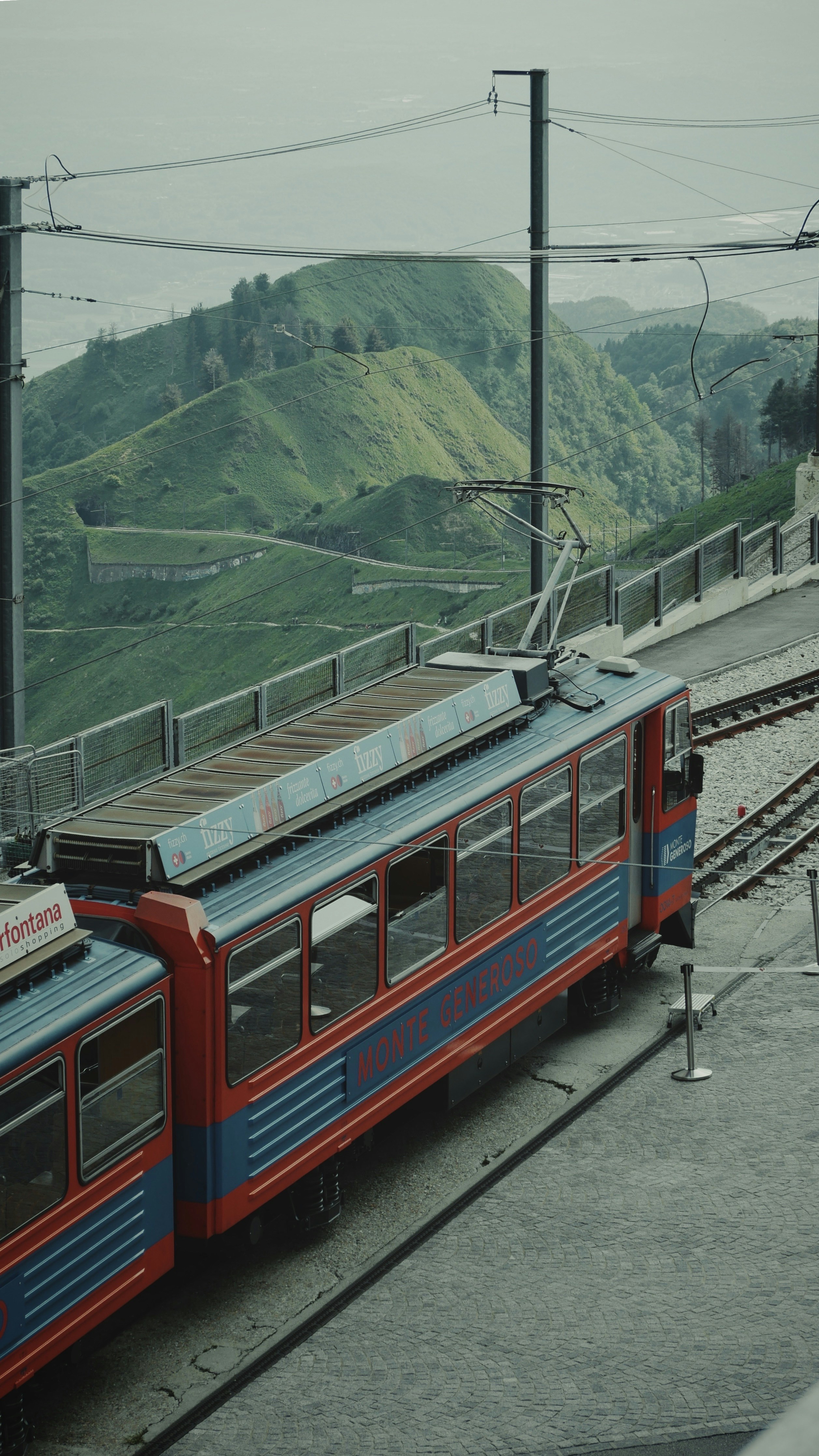 ein roter und blauer Zug, der die Bahngleise hinunterfährt