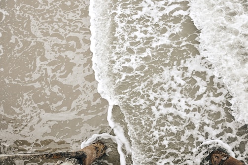 A framed video clip showing waves gently crashing on a sandy beach at sunset.
