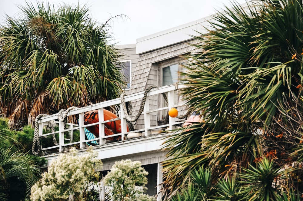 a house with palm trees and a man on a balcony