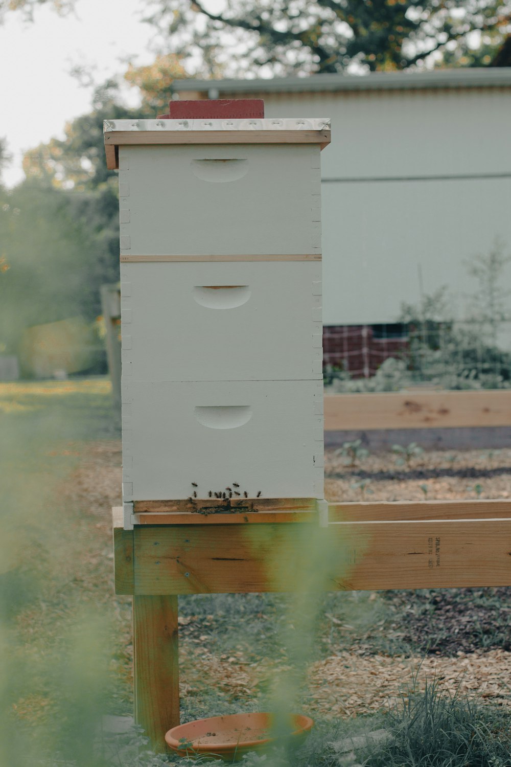 a beehive sitting on top of a wooden post