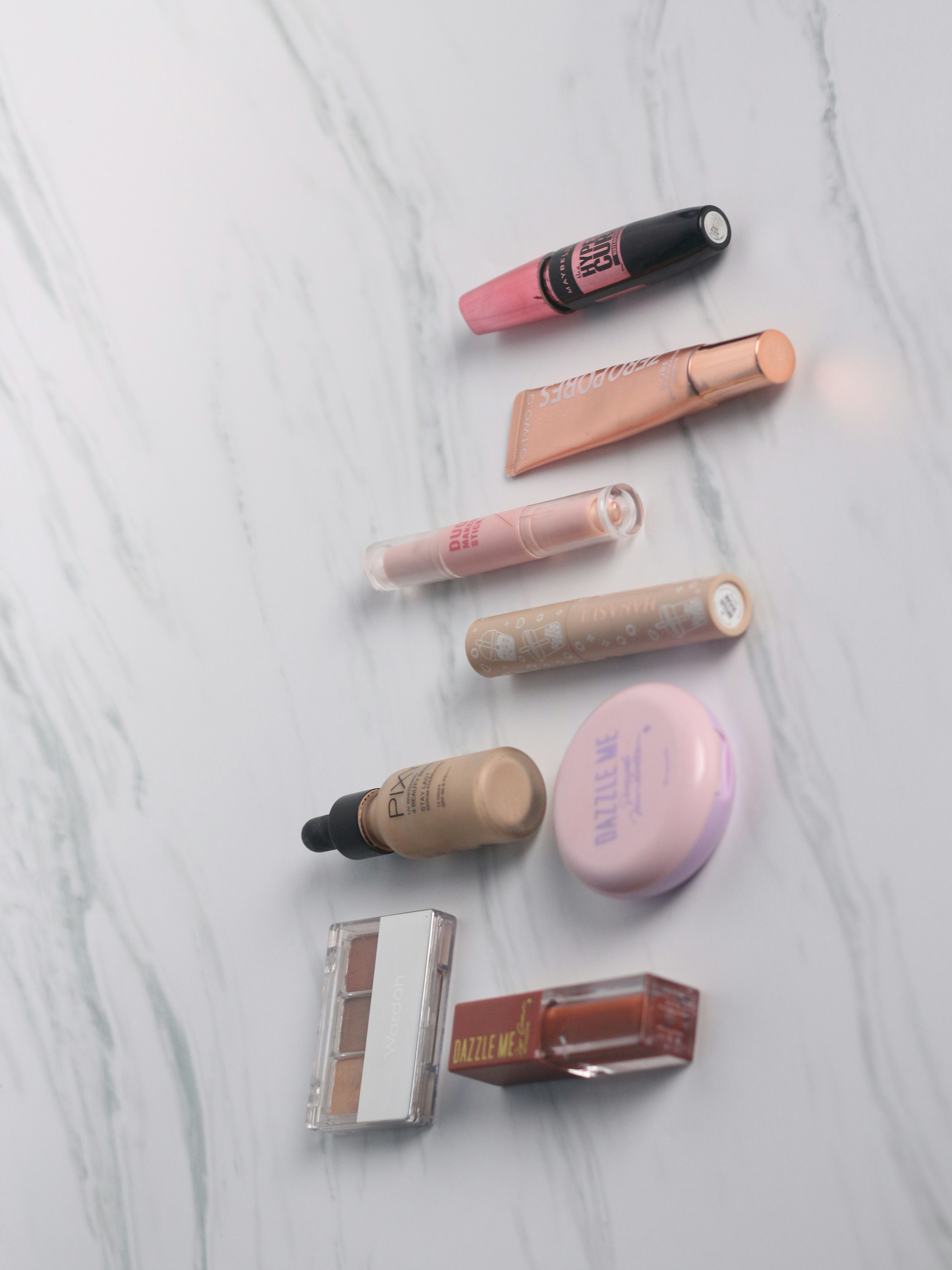 Minimal makeup products arranged elegantly on marble, soft studio lighting, clean and bright