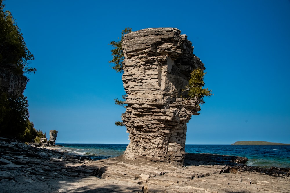 a rock formation on a beach near the ocean