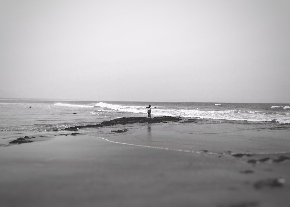 a person standing on a beach next to the ocean