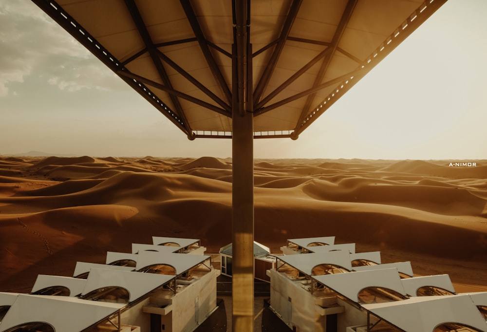 a desert setting with tables and chairs under a canopy