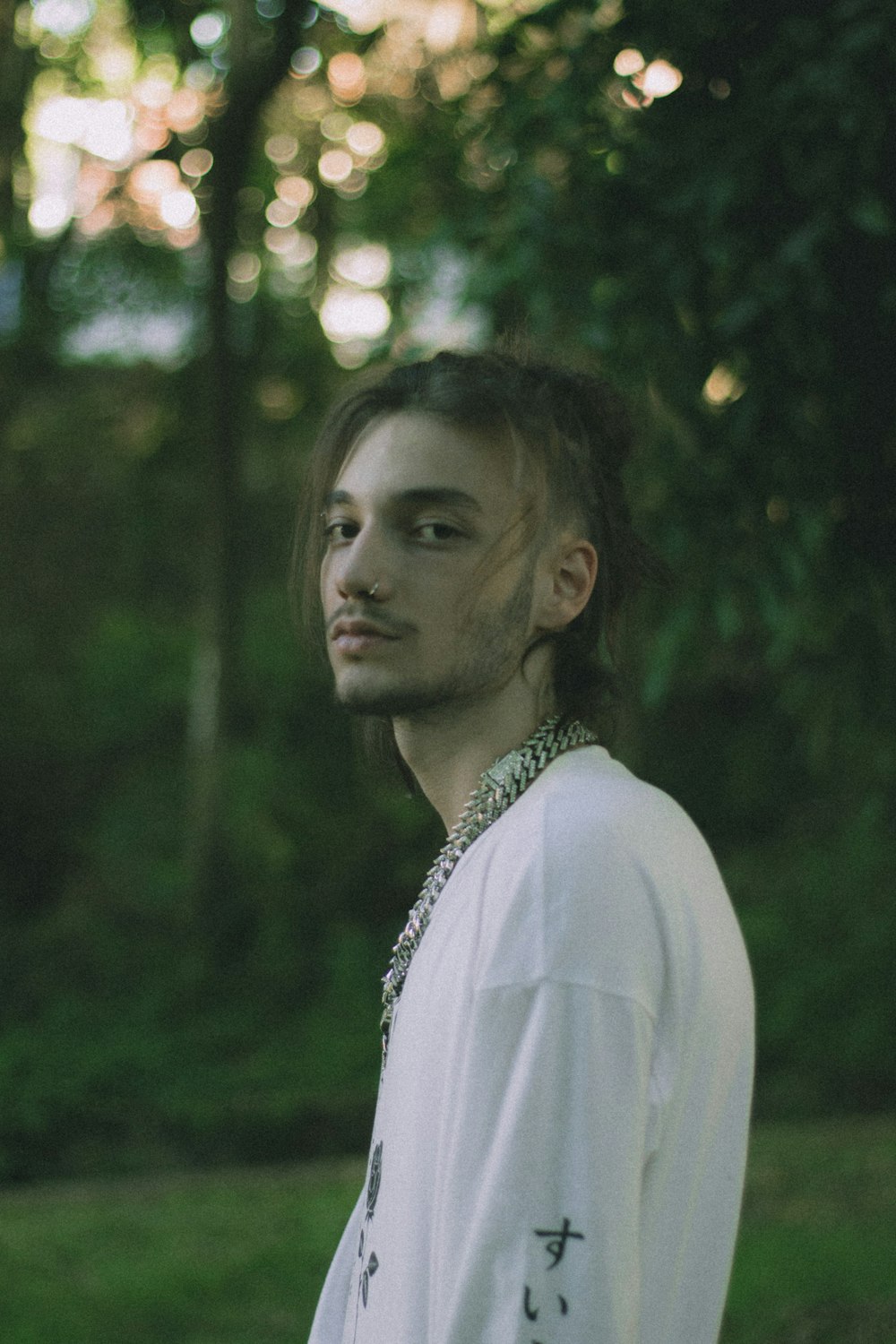 a man with long hair wearing a white shirt