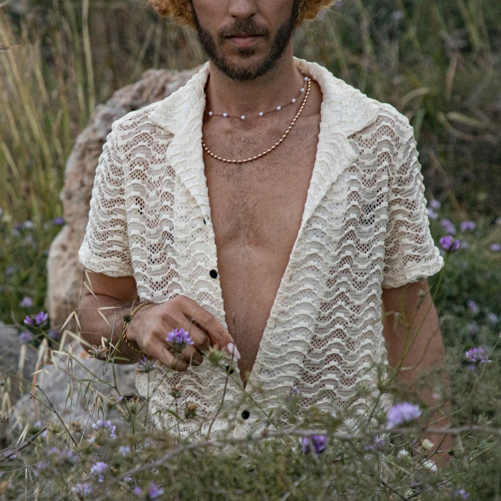 a shirtless man in a field of wildflowers