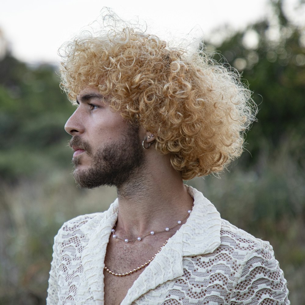 a man with blonde hair wearing a white shirt