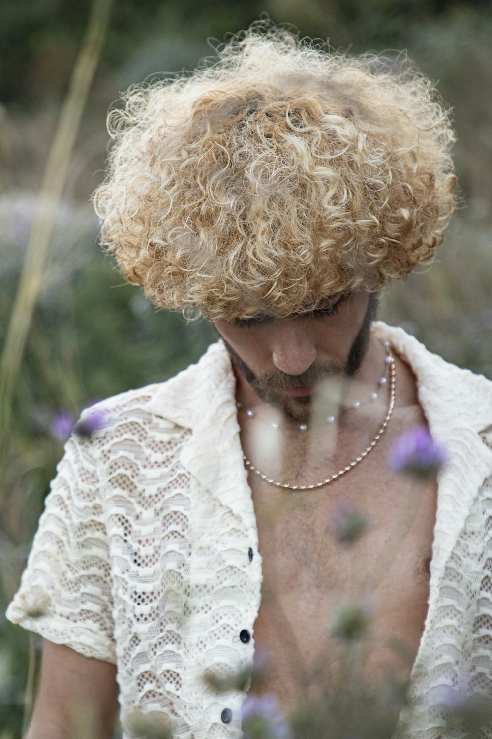 a shirtless man in a field of flowers