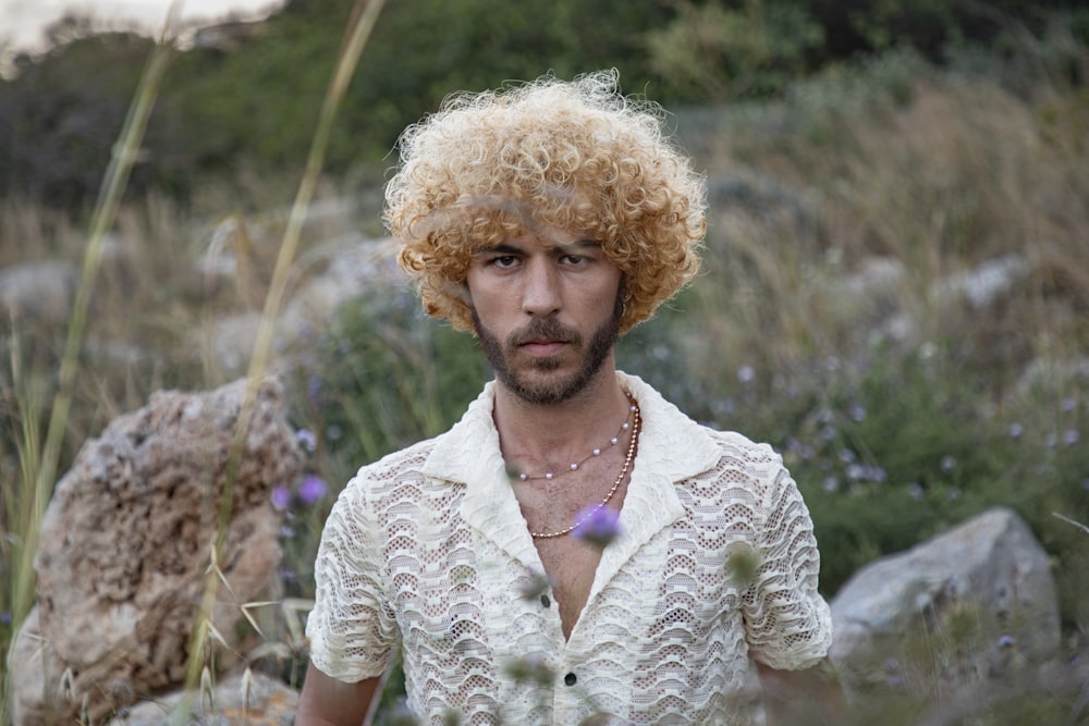 a man with blonde hair wearing a white shirt