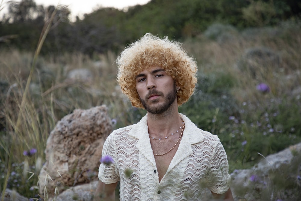 a man with blonde hair wearing a white shirt