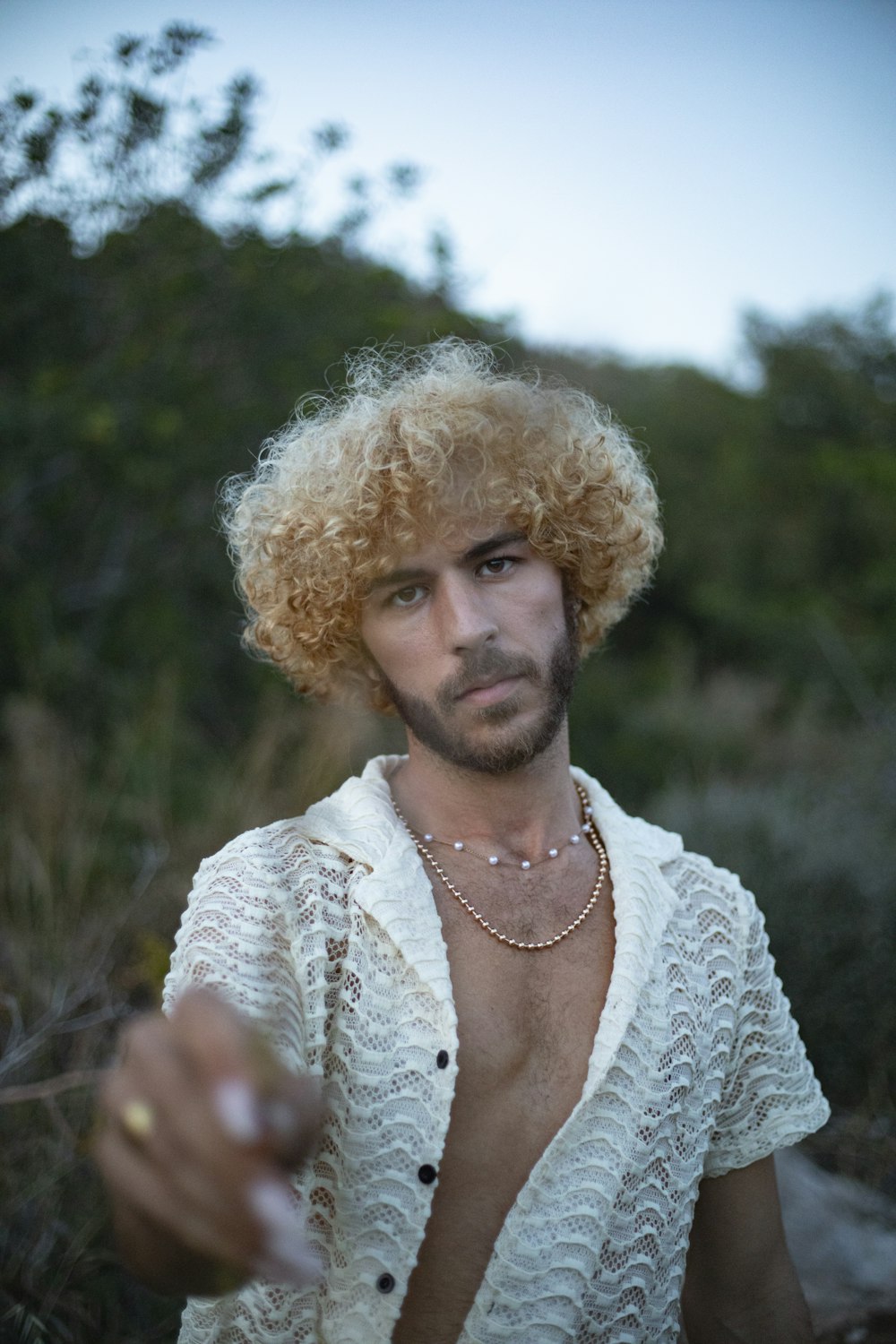 a man with blonde hair wearing a white shirt