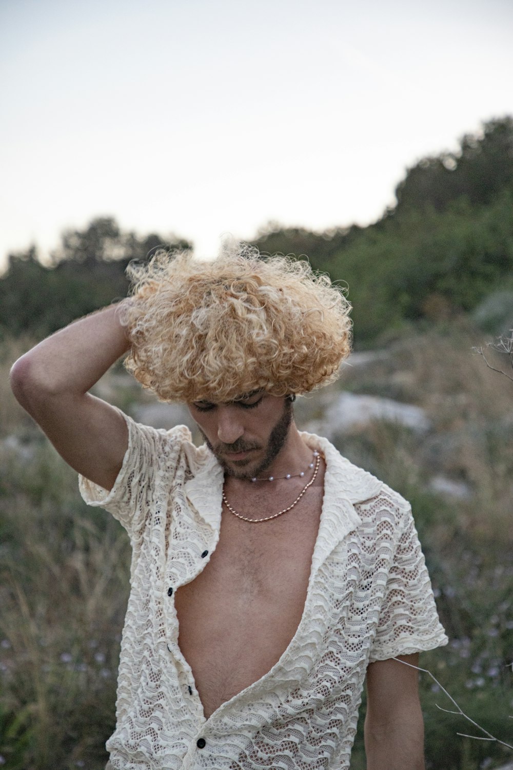 a man with curly hair wearing a white shirt