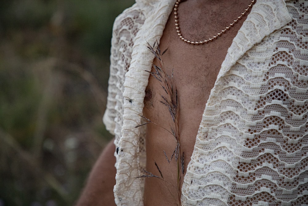 a man wearing a white shawl with a plant on it