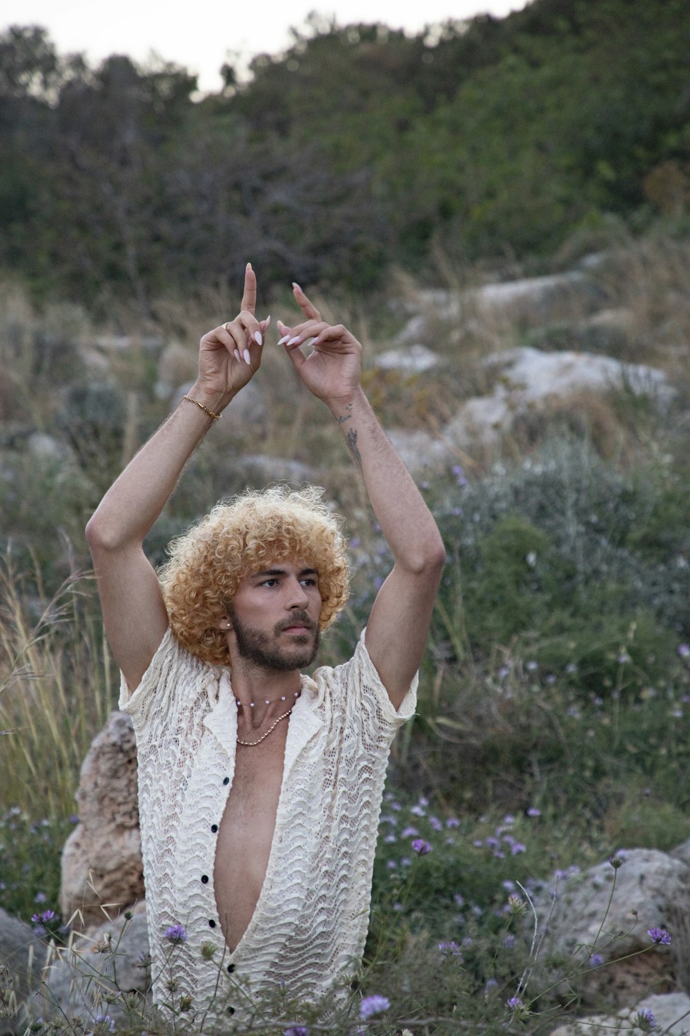 a man with an afro standing in a field