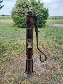 Close-up of hands inspecting a water pump system outdoors.