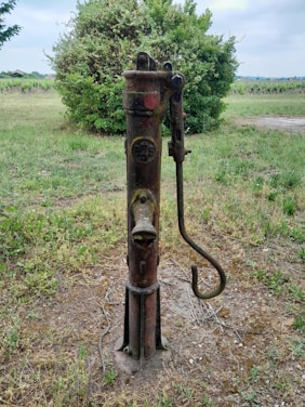 Technician repairing a well pump outdoors on a sunny day.