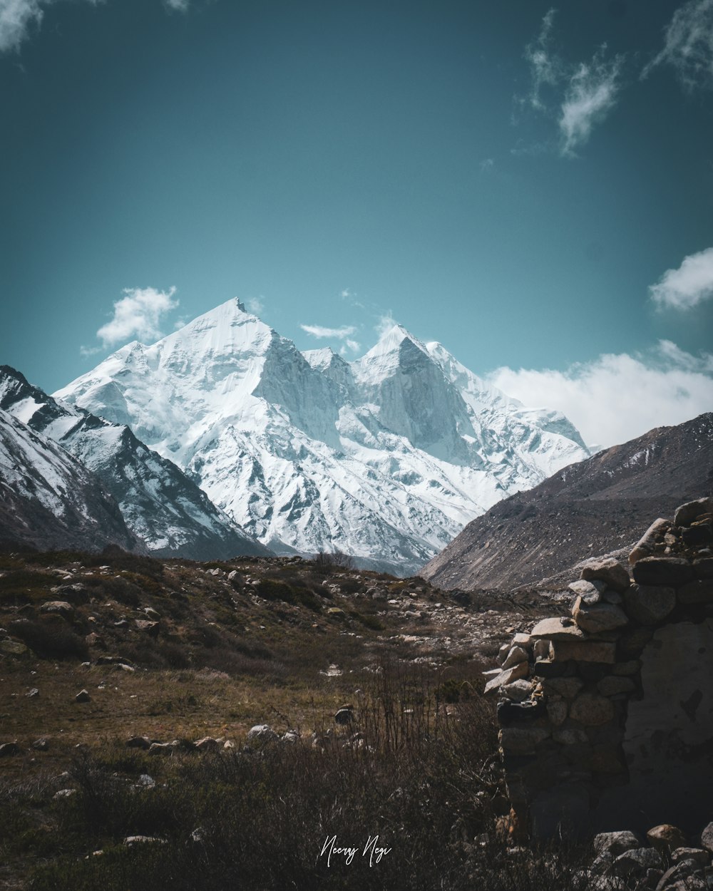 a mountain range with a stone wall in the foreground