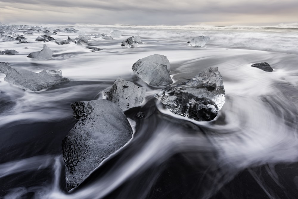 a black and white photo of rocks and water