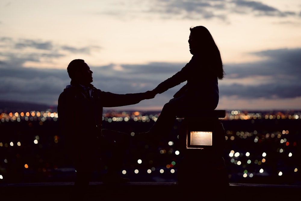 a couple of people sitting on top of a bench