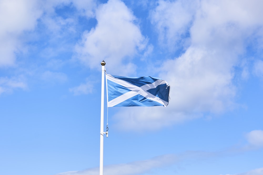 a blue and white flag flying in the wind