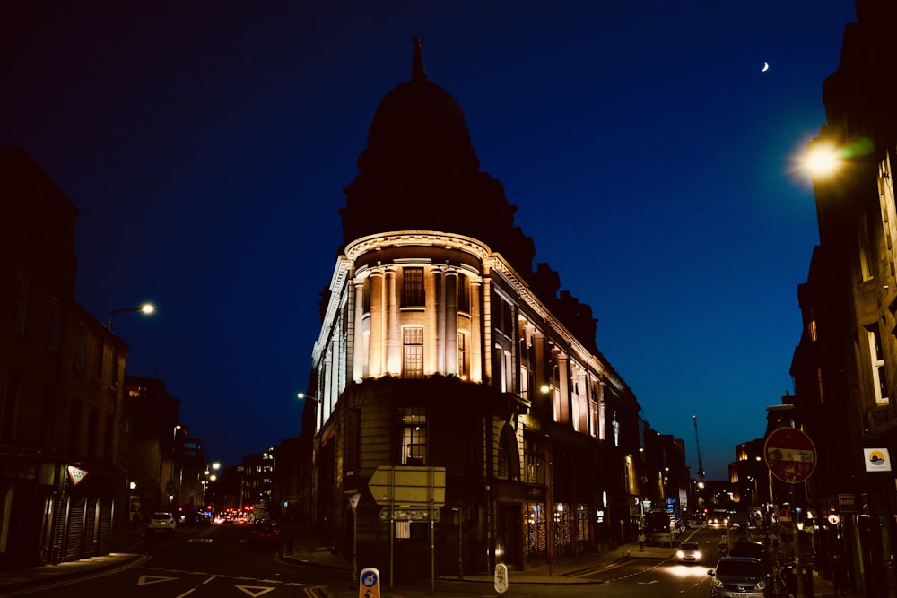 a city street at night with a building lit up