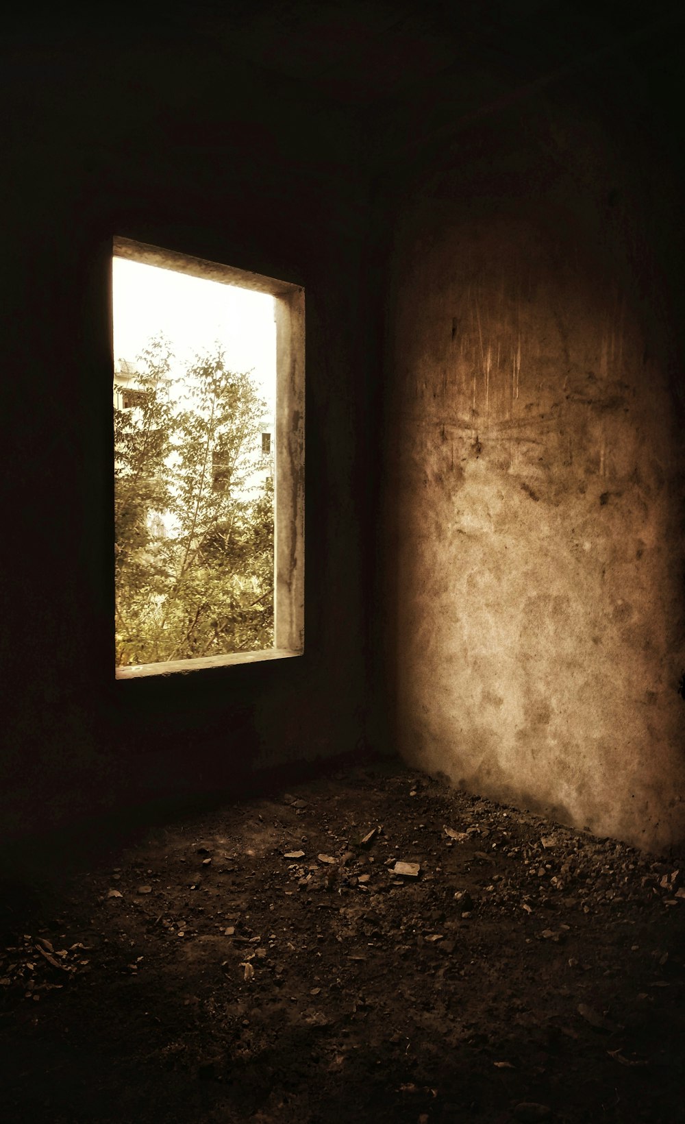 a dark room with a window and dirt floor