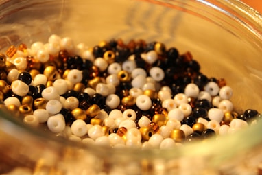 a glass bowl filled with black and white beads