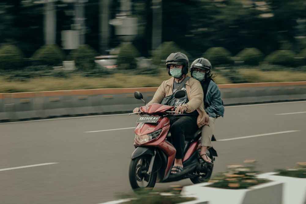 two people riding a motorcycle down a street