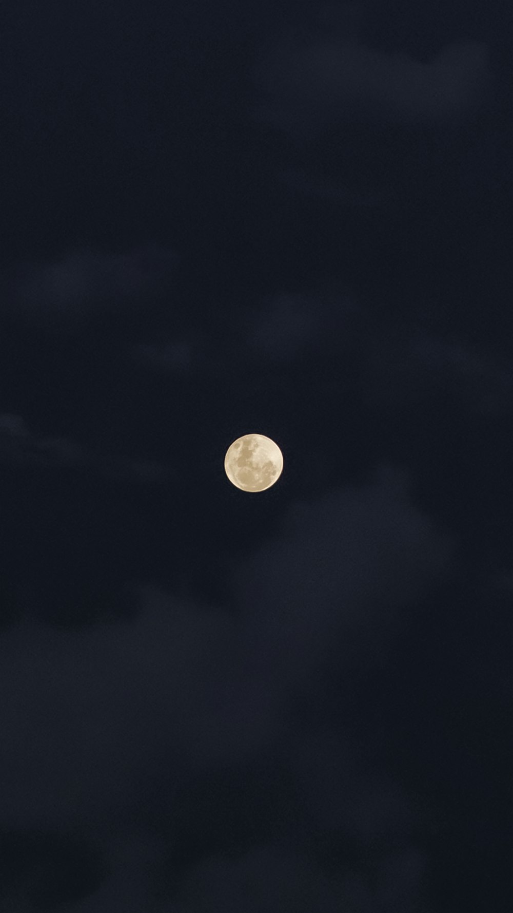 a full moon is seen in the dark sky