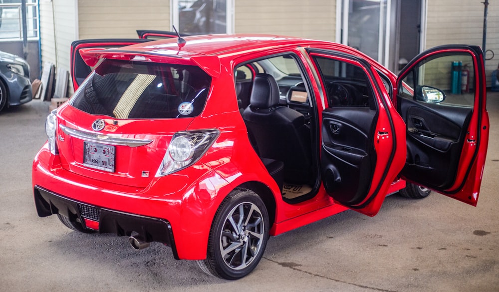 a small red car with its door open