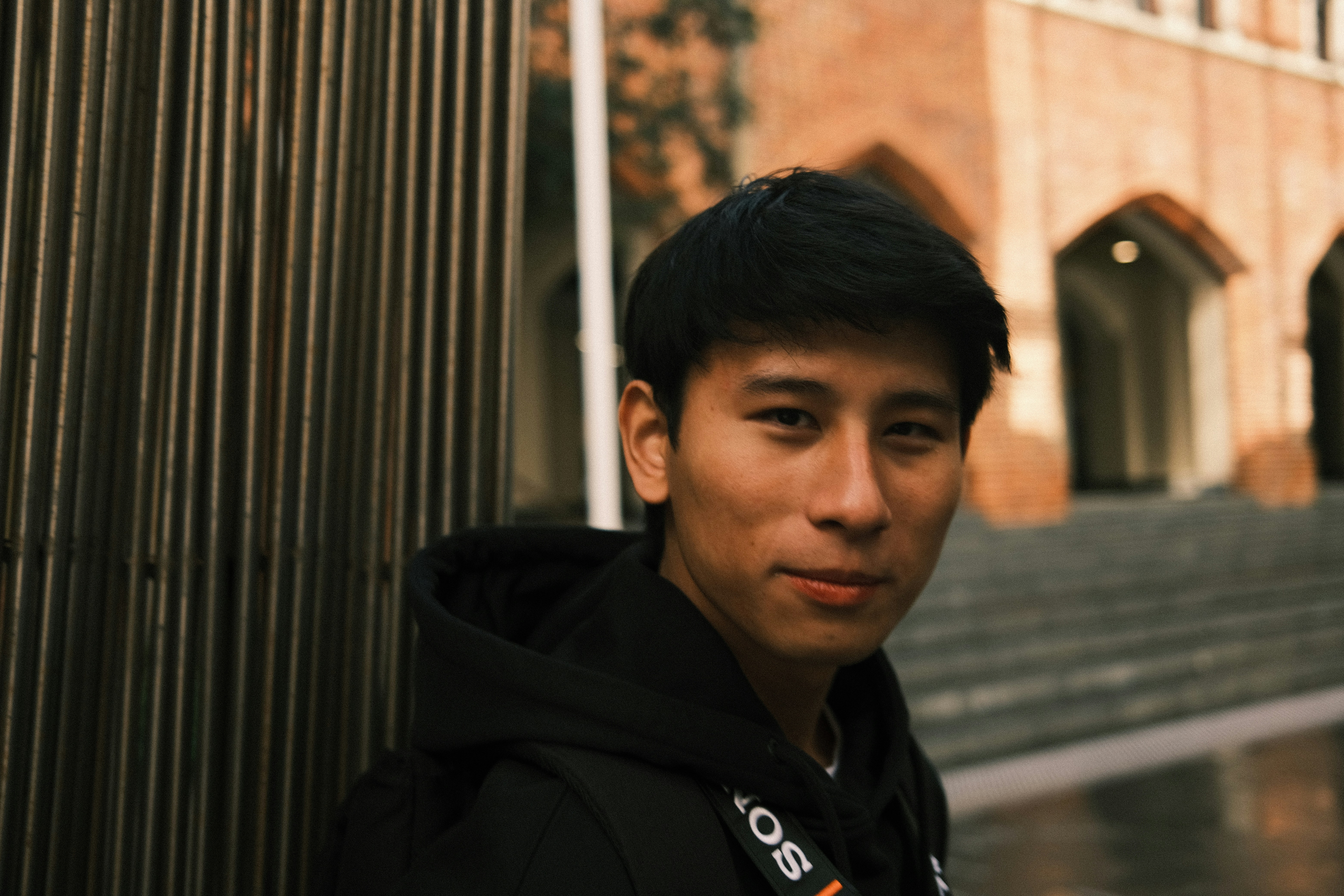a young man standing in front of a building