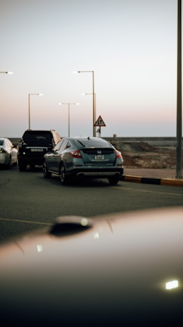 A dark-themed roadside assistance vehicle helping a car on a coastal road near Çeşme.