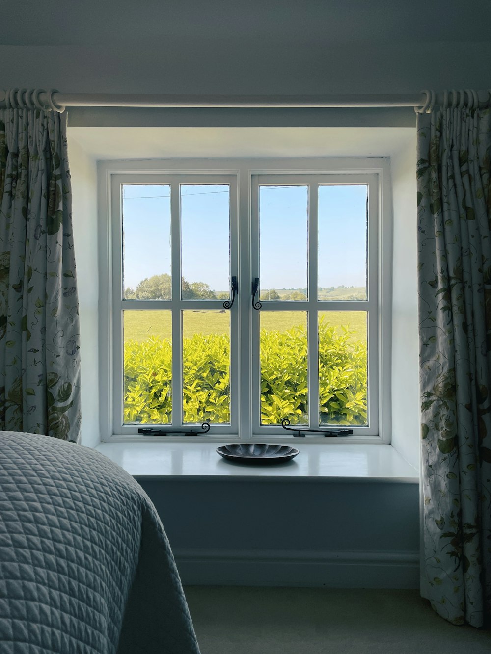 a bedroom with a bed and a large window