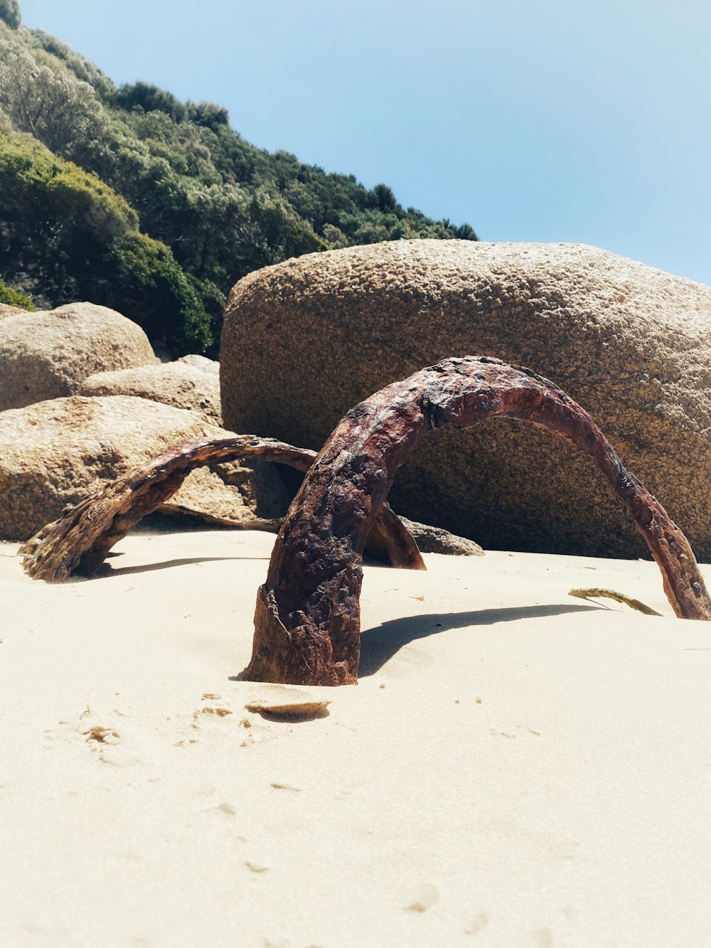 a piece of metal sitting on top of a sandy beach