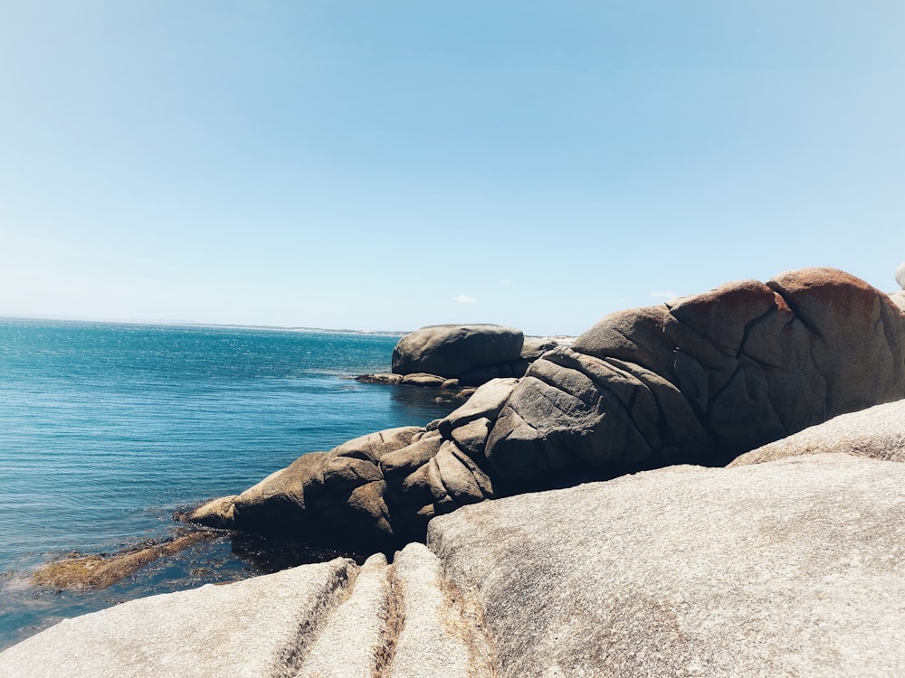 a rock formation on the edge of a body of water