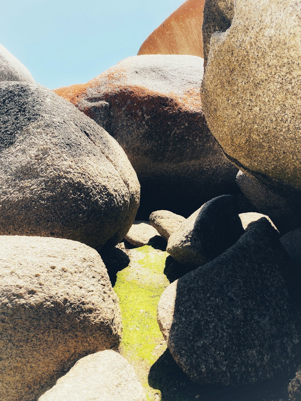 a close up of rocks and grass with a sky background