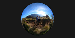 A panoramic view of the equatorial line marker with travelers smiling and taking photos.