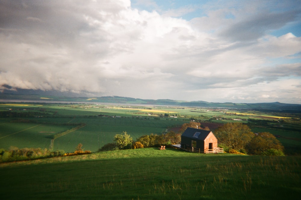 a house on a hill with a cloudy sky