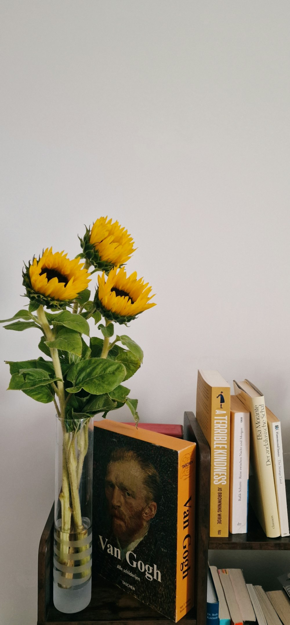 a vase filled with yellow flowers next to books