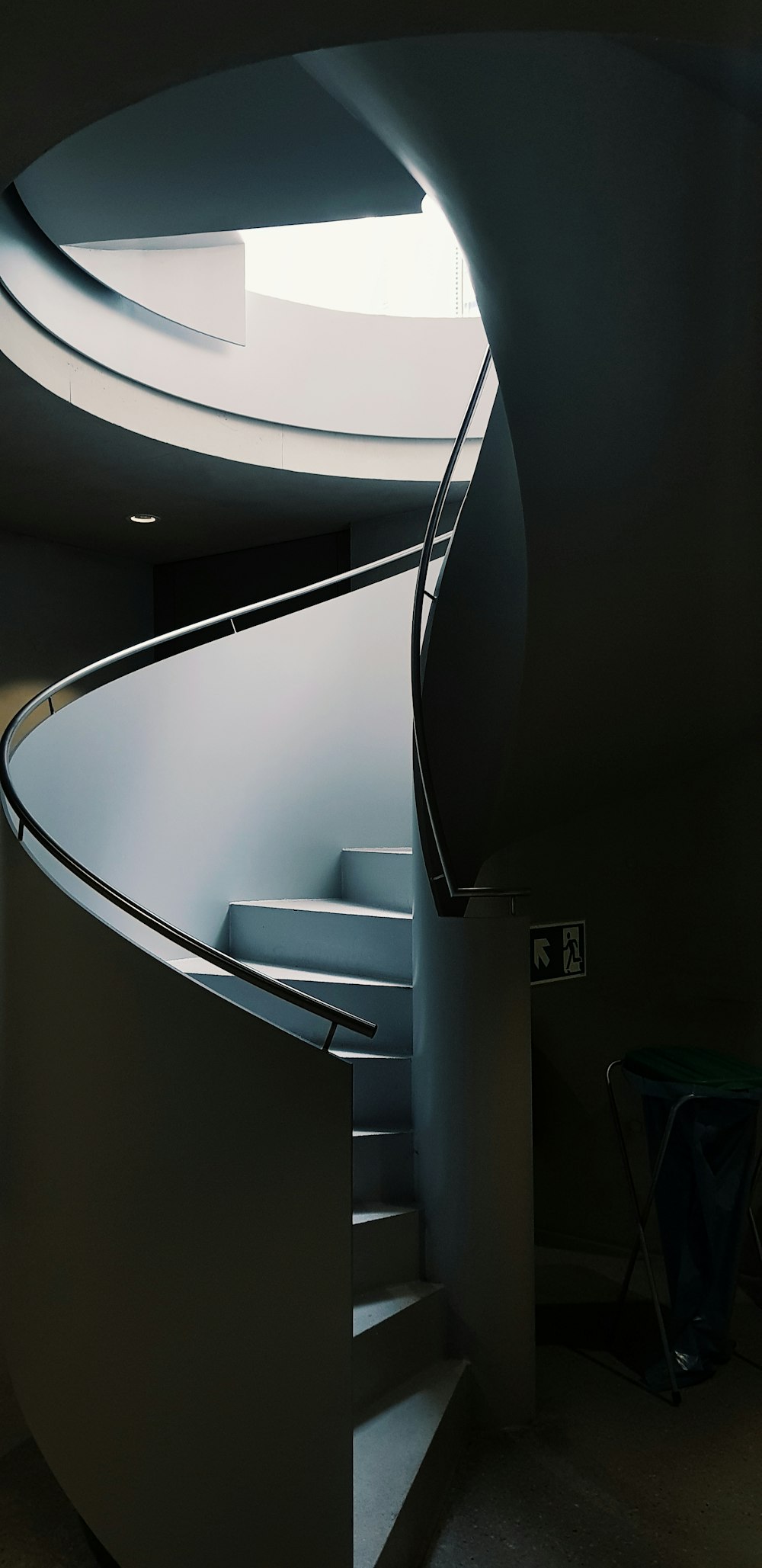 a spiral staircase in a building with a skylight