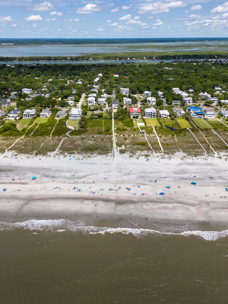Angled aerial drone view of homes with surrounding area and landscape