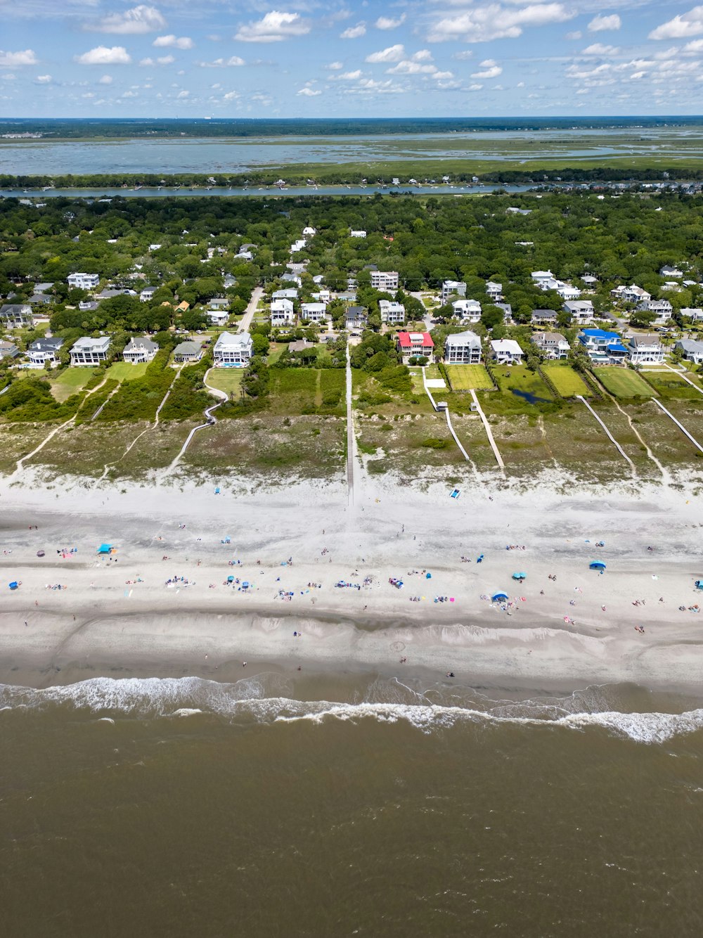 an aerial view of a beach with houses in the background