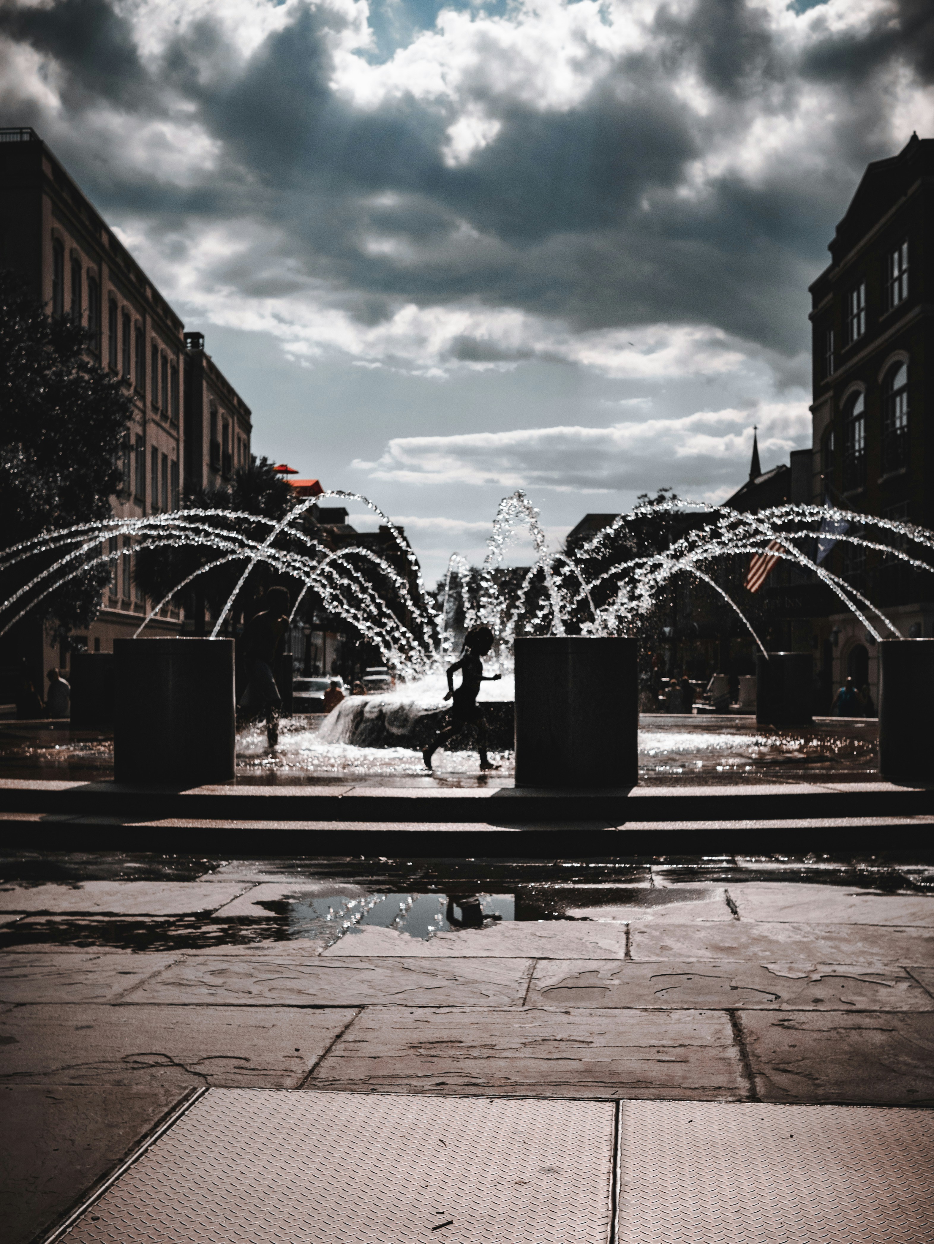 a person sitting on a bench in front of a fountain
