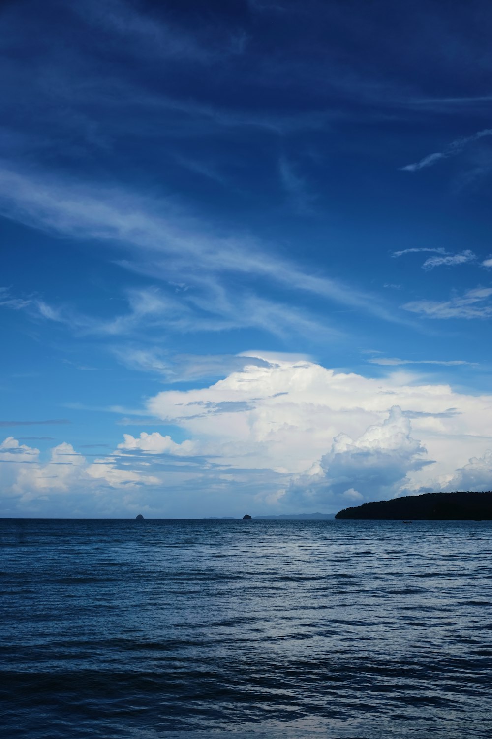 a large body of water under a cloudy blue sky