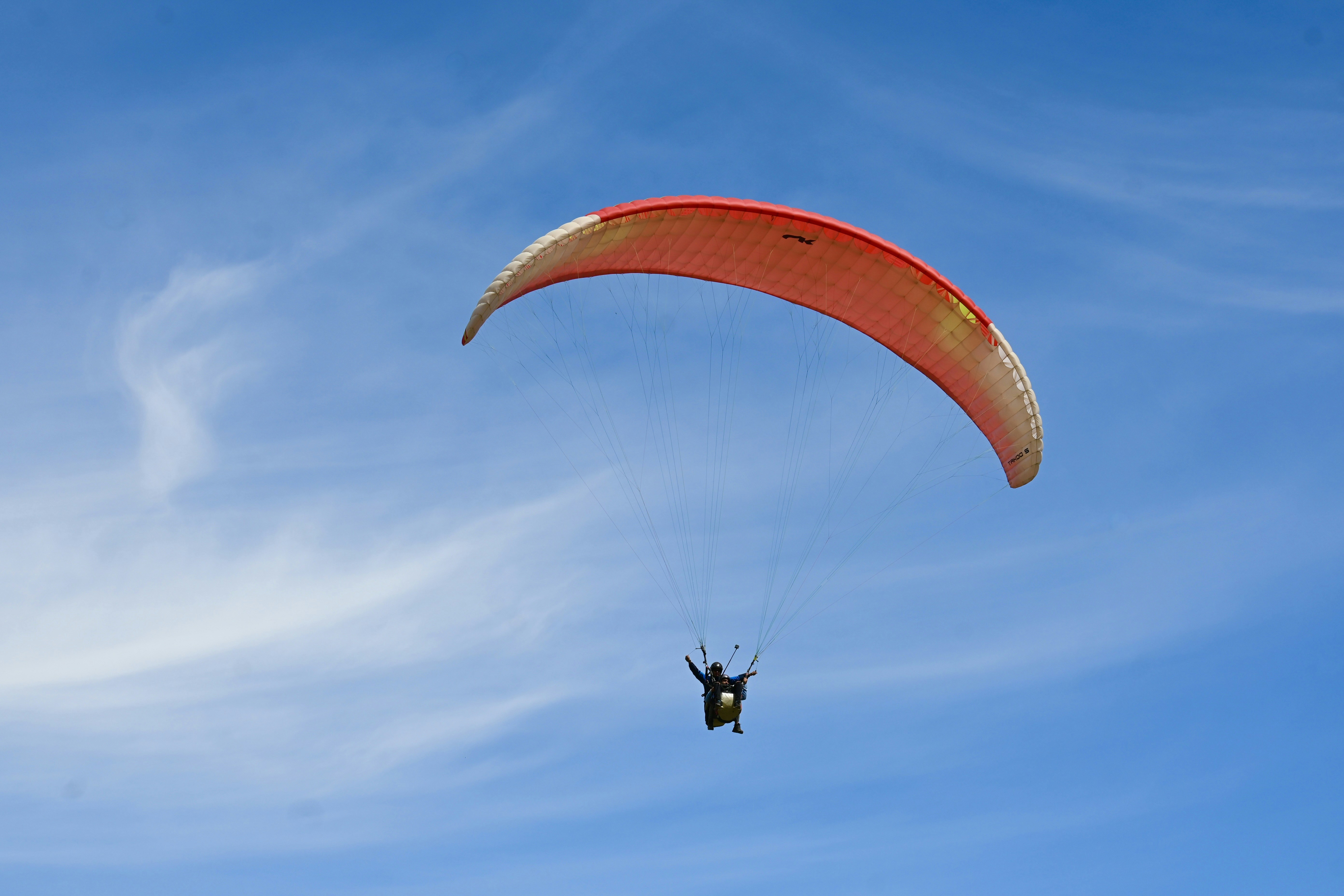 a person is parasailing in the blue sky