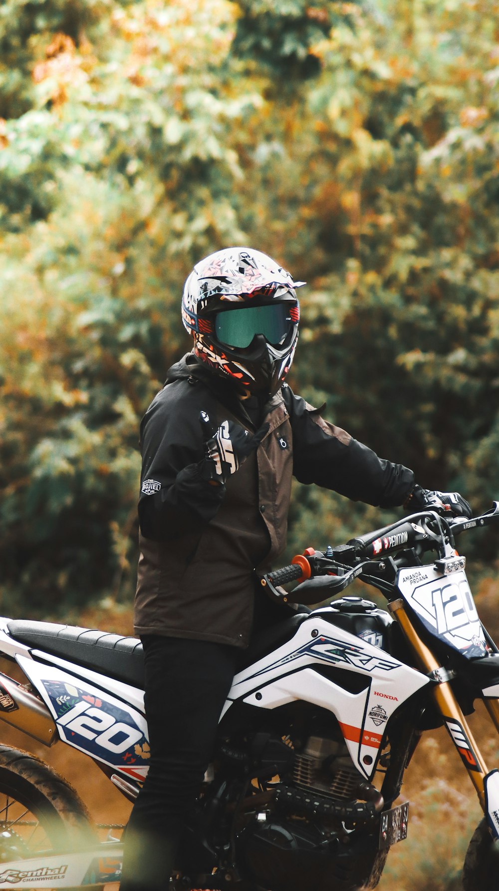 a person sitting on a dirt bike on a dirt road