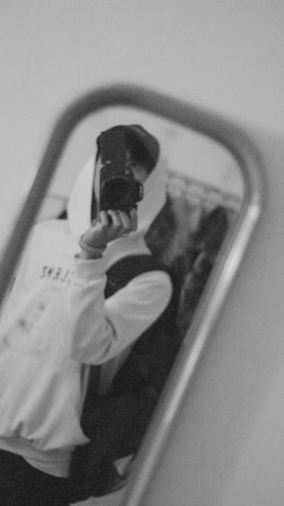 Black and white photo of a sleek hoodie with a built-in backpack and hidden pockets.
