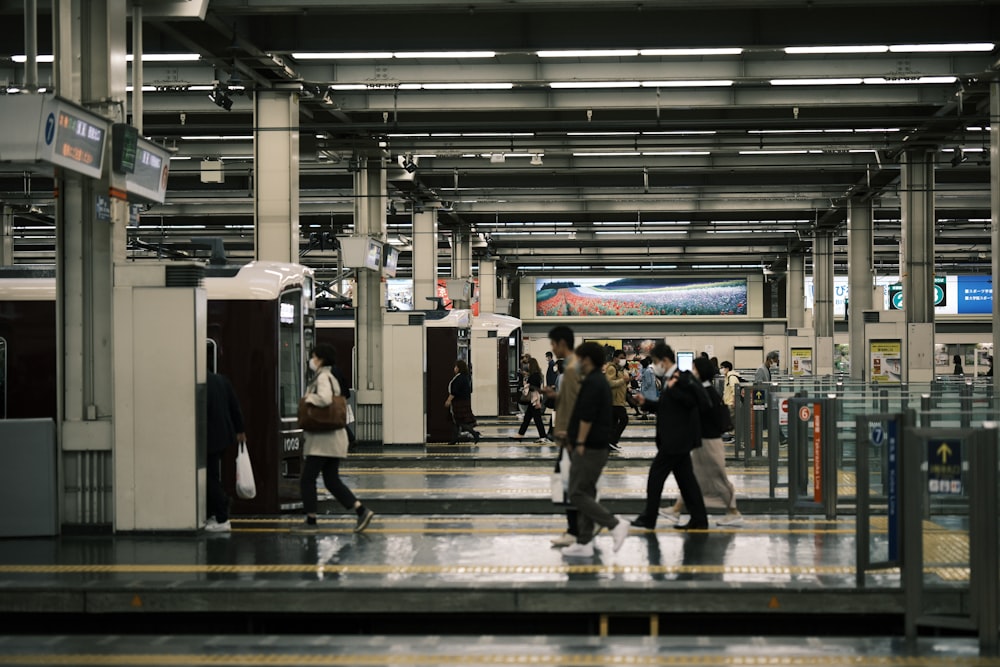 a group of people walking through a train station